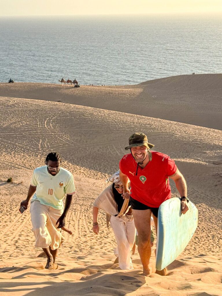 Surf students running down the sand dunes with their boards