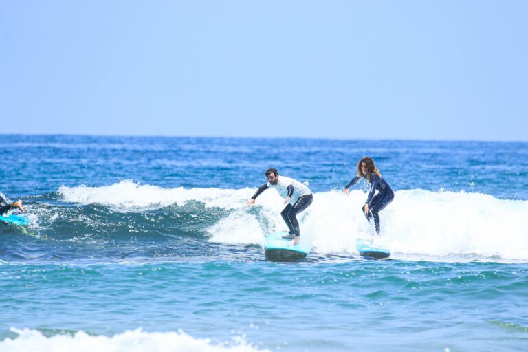 Two surfers riding a wave together during a surf session in Taghazout Bay