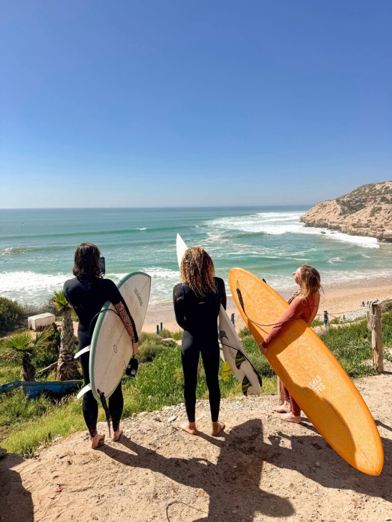 Surfers with boards looking over the bay before a guided session near Taghazout