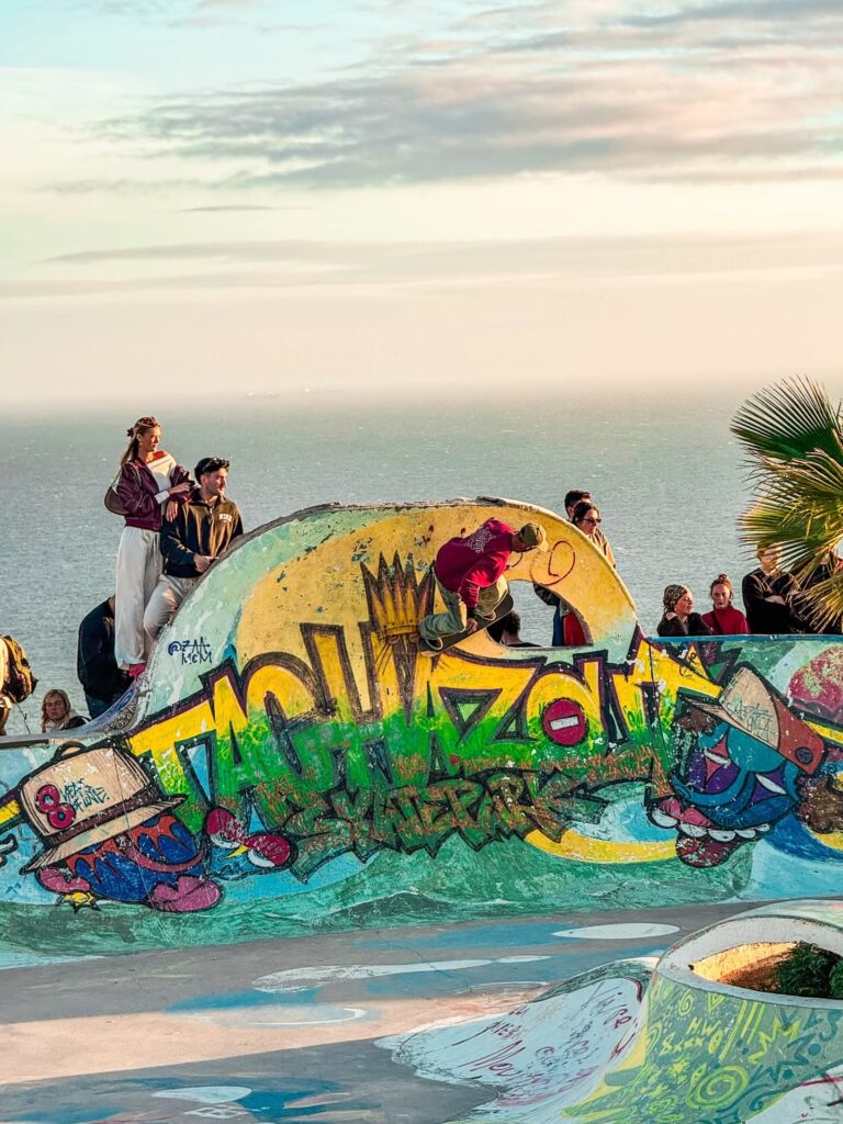 Sunset at the colourful Taghazout sign above the ocean