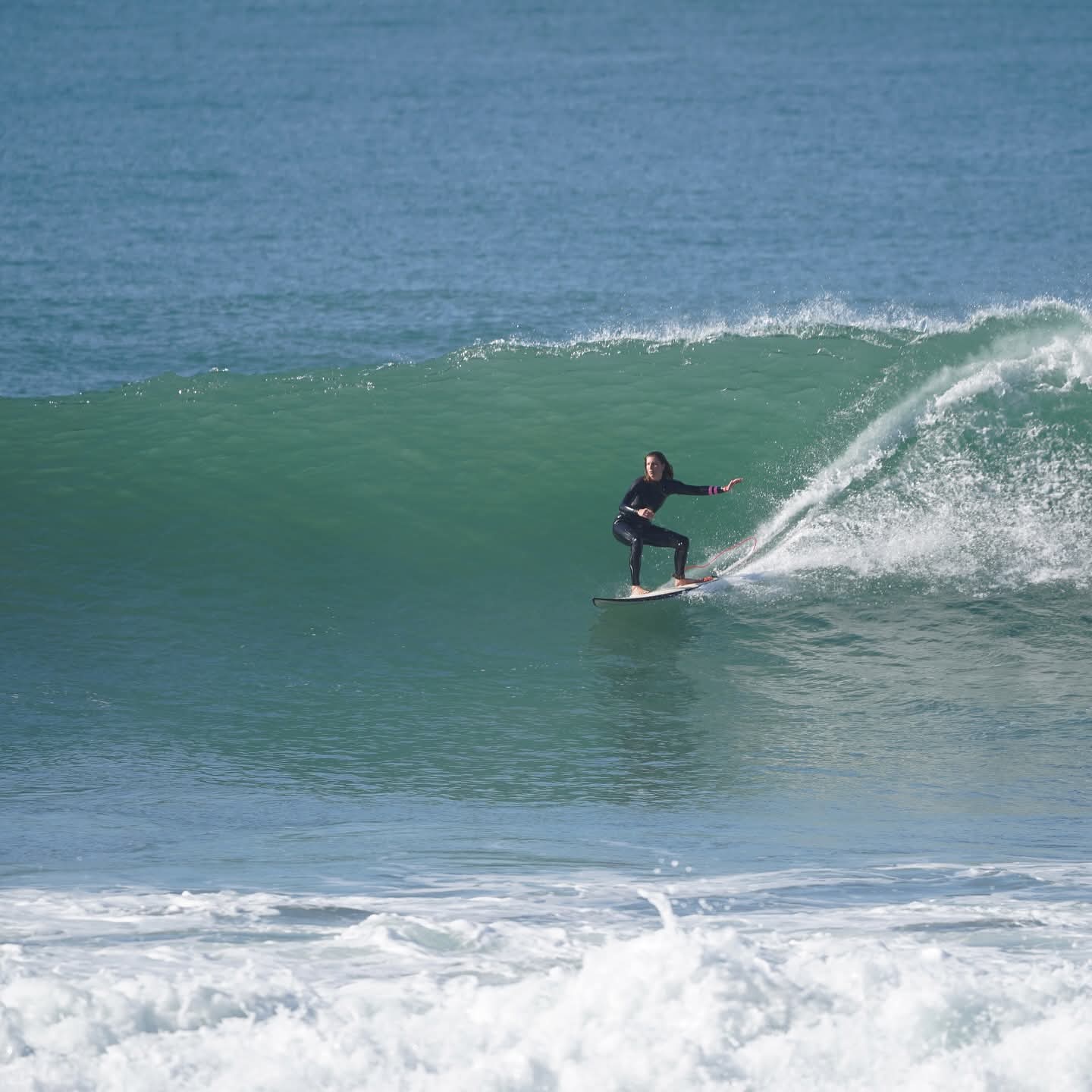 Surfer carving a green wave at a point break near Taghazout
